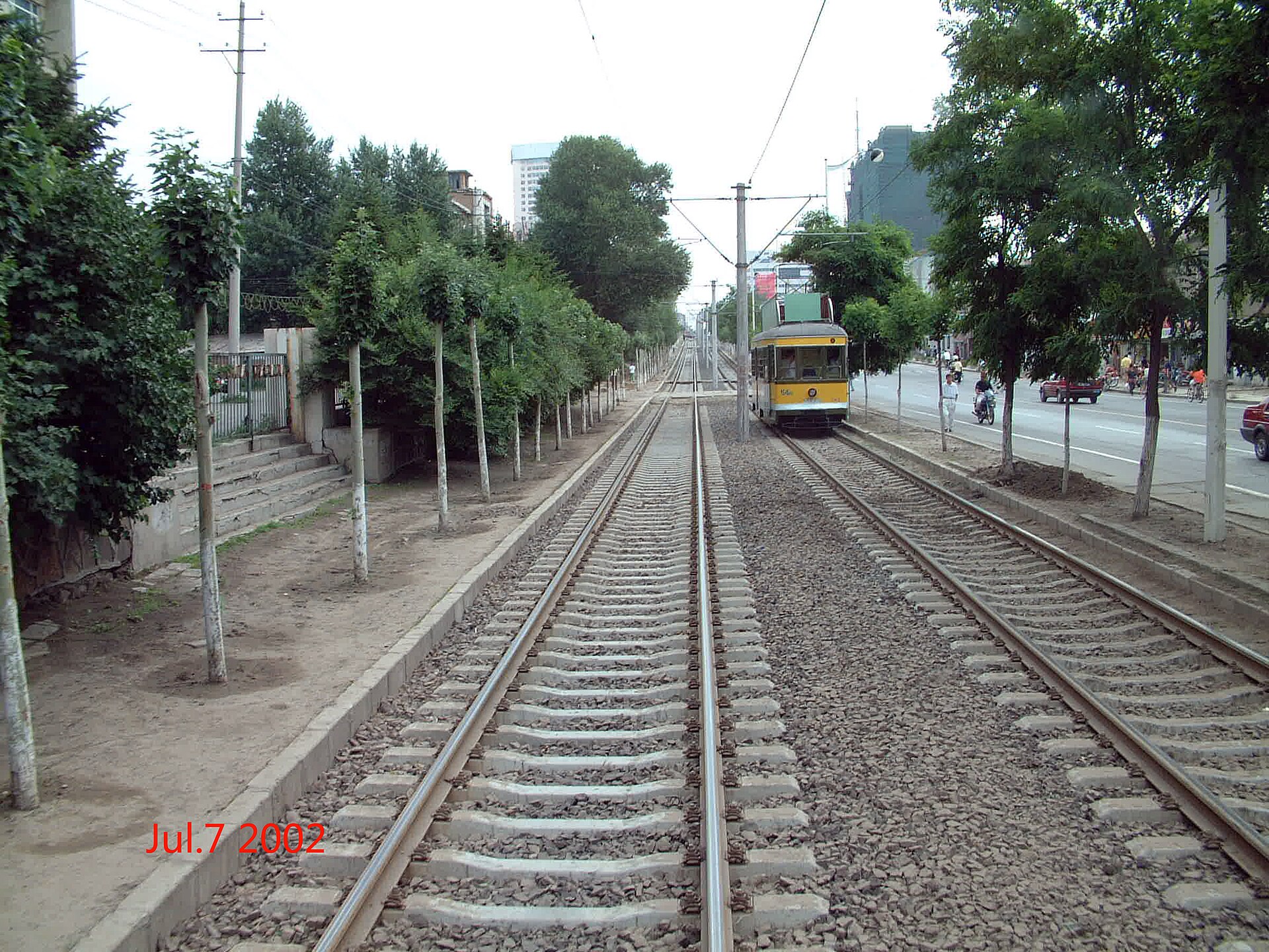 Dated July 2002 photograph of a yellow Changchun tram