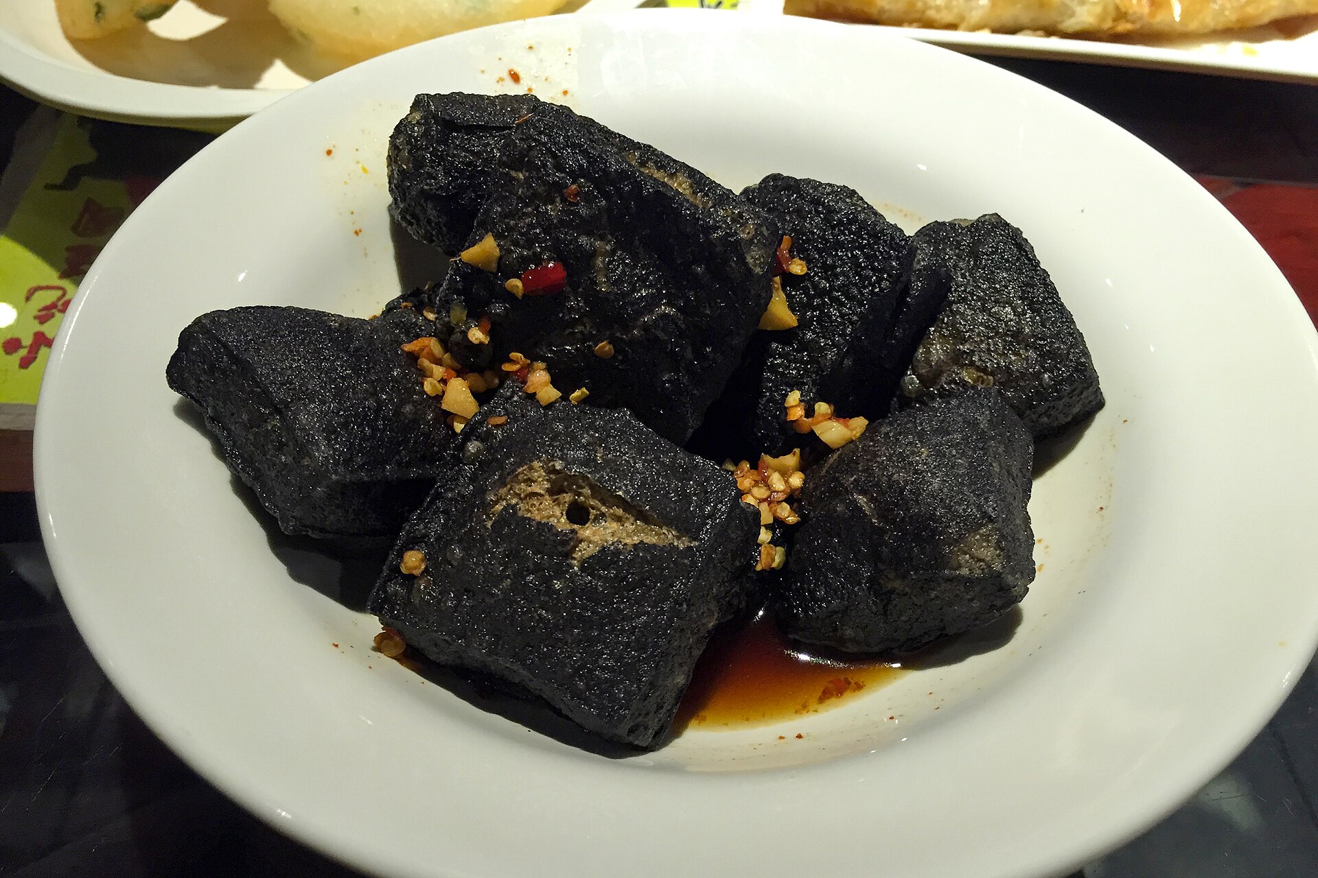Dark fried Changsha-style stinky tofu on a white plate