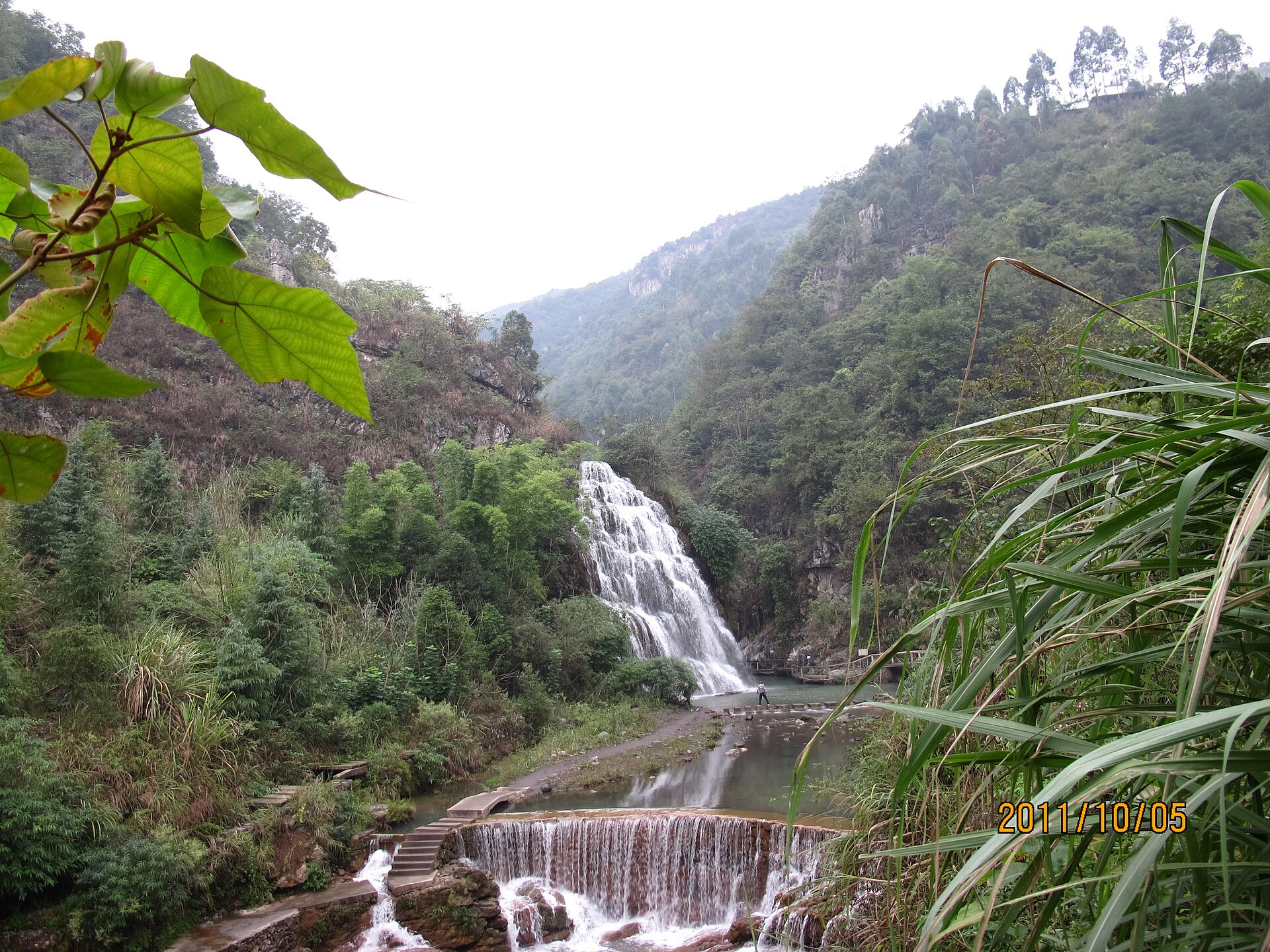 Dated forest waterfall and managed stream in Linshui