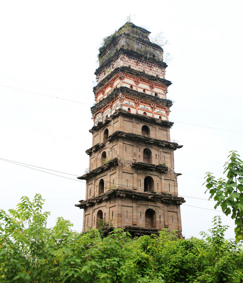 Weathered Guang'an White Pagoda rising above vegetation