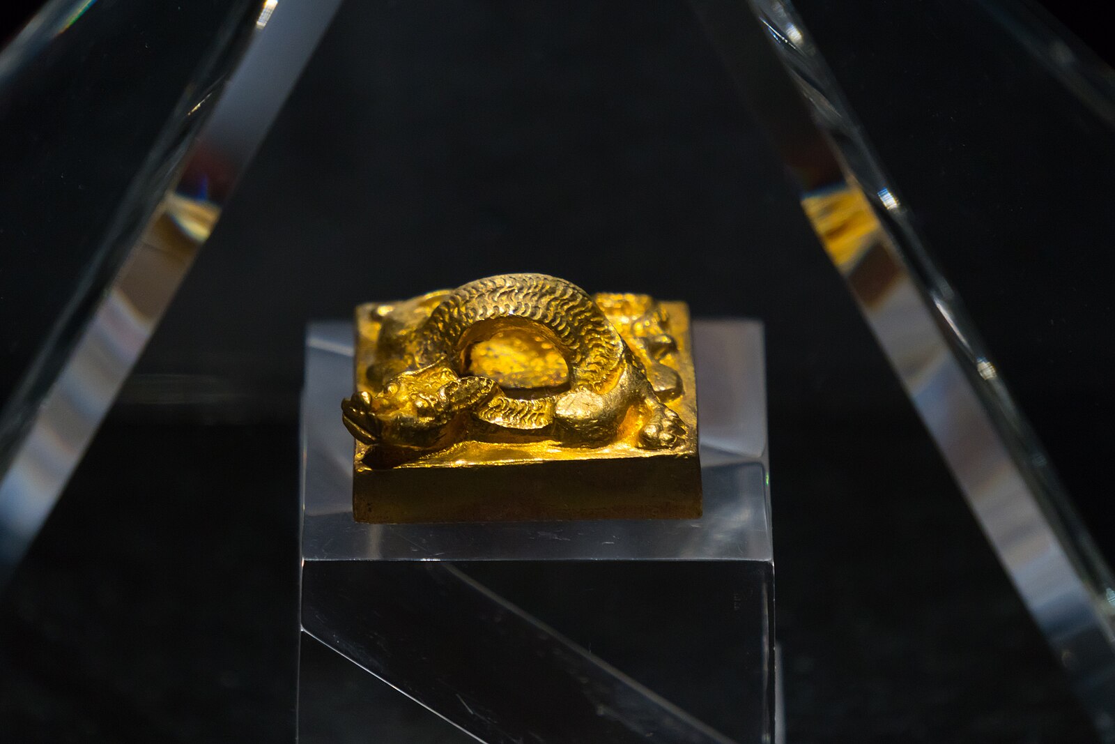 Gold seal with a coiled dragon knob in a museum case