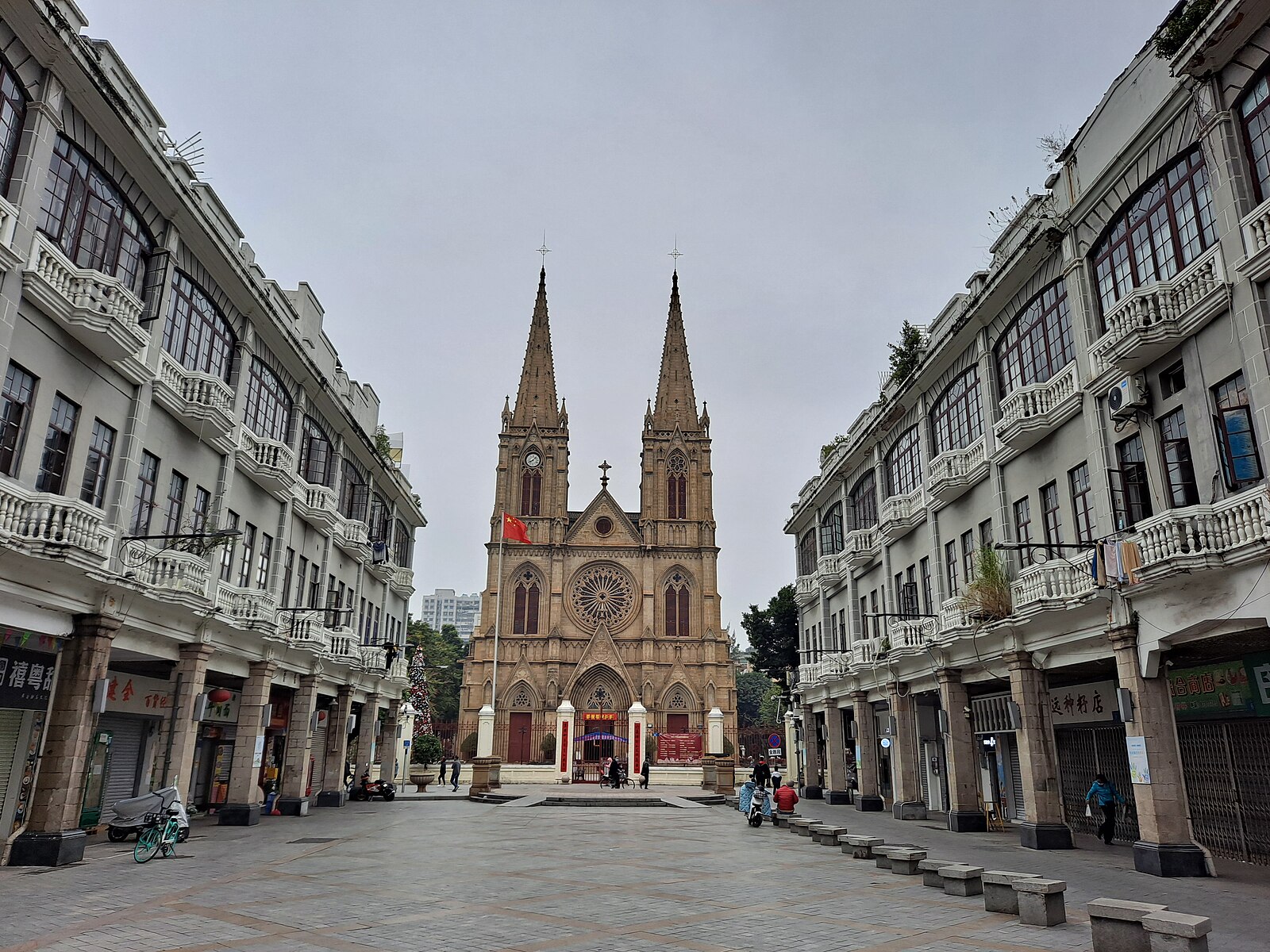 Twin-spired stone cathedral at the end of a Guangzhou street