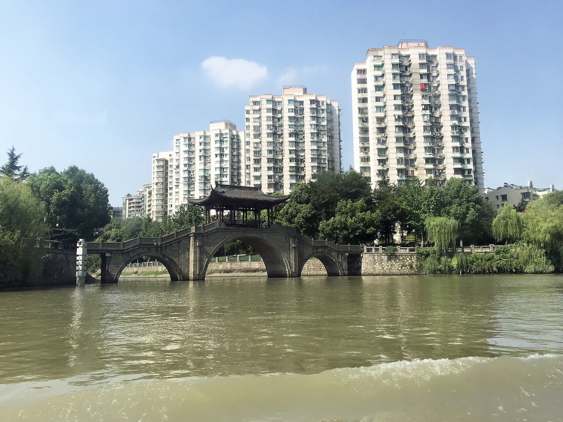 Grand Canal waterway, boats, bridge and later urban buildings in Hangzhou