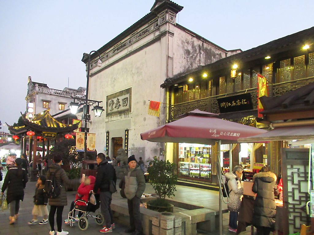 Dated evening view of Hefang Street with shops, lanterns and pedestrians