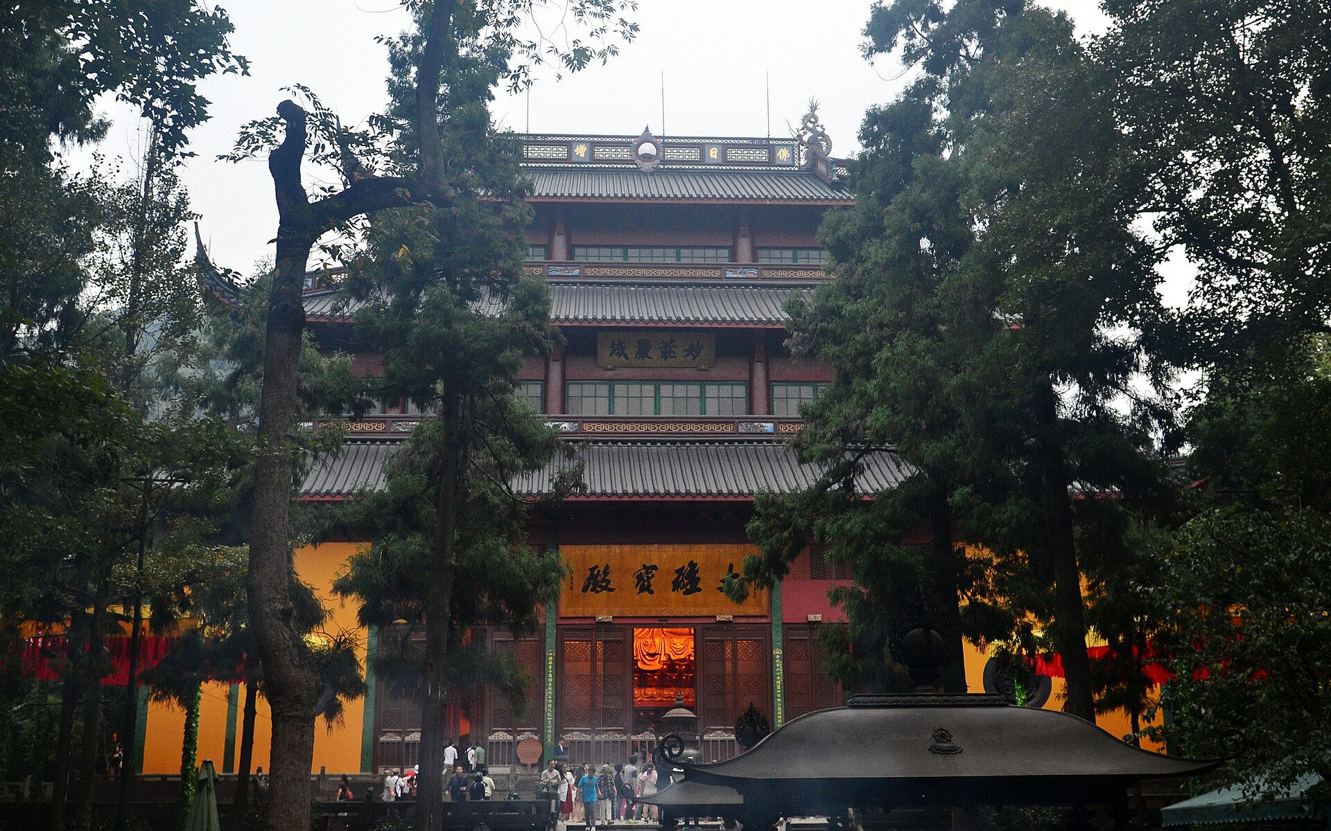 Mahavira Hall and yellow walls of Lingyin Temple seen through mature trees