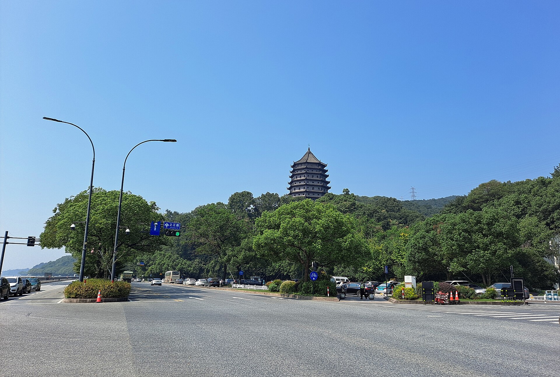 Distant Liuhe Pagoda above a wooded hill and modern roadway