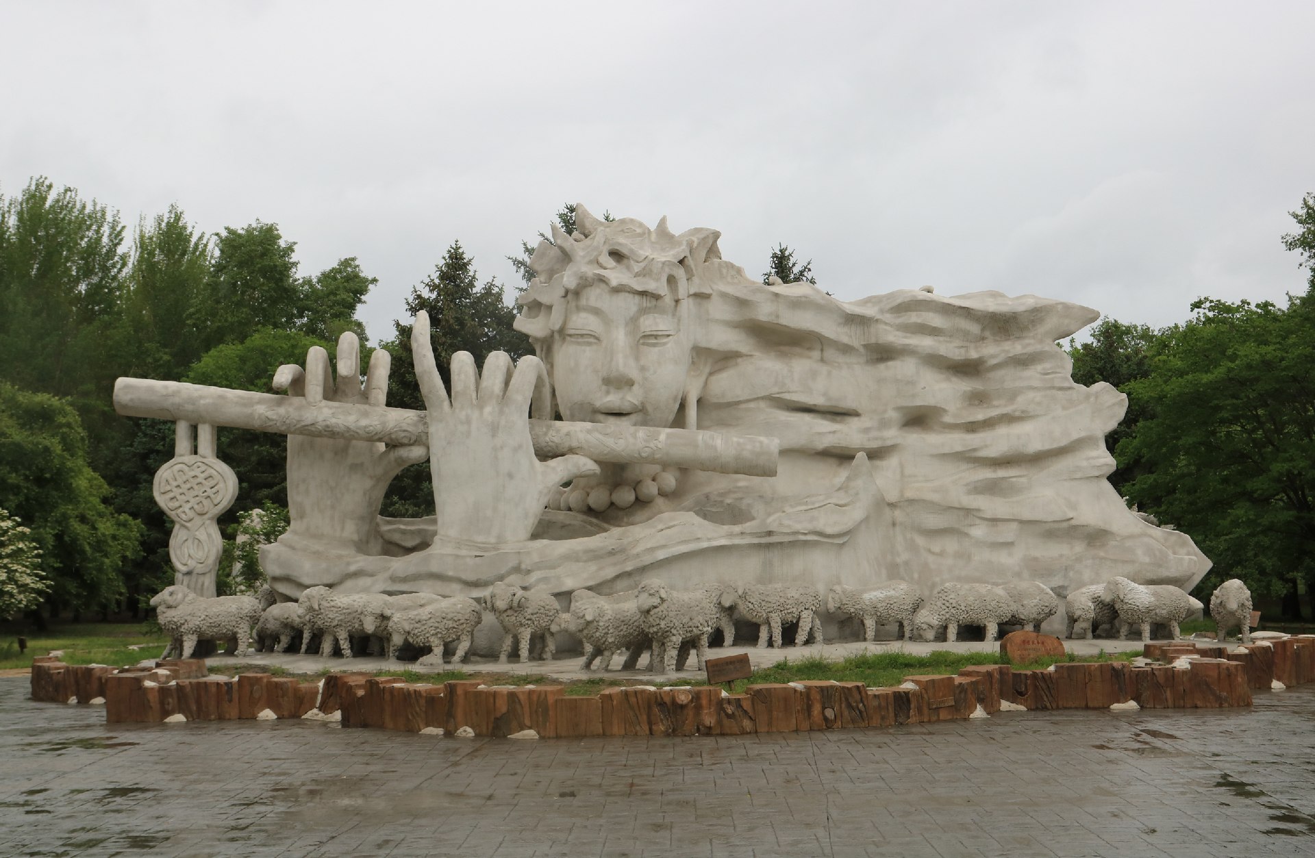 Large flute-player sculpture and sheep figures on Sun Island