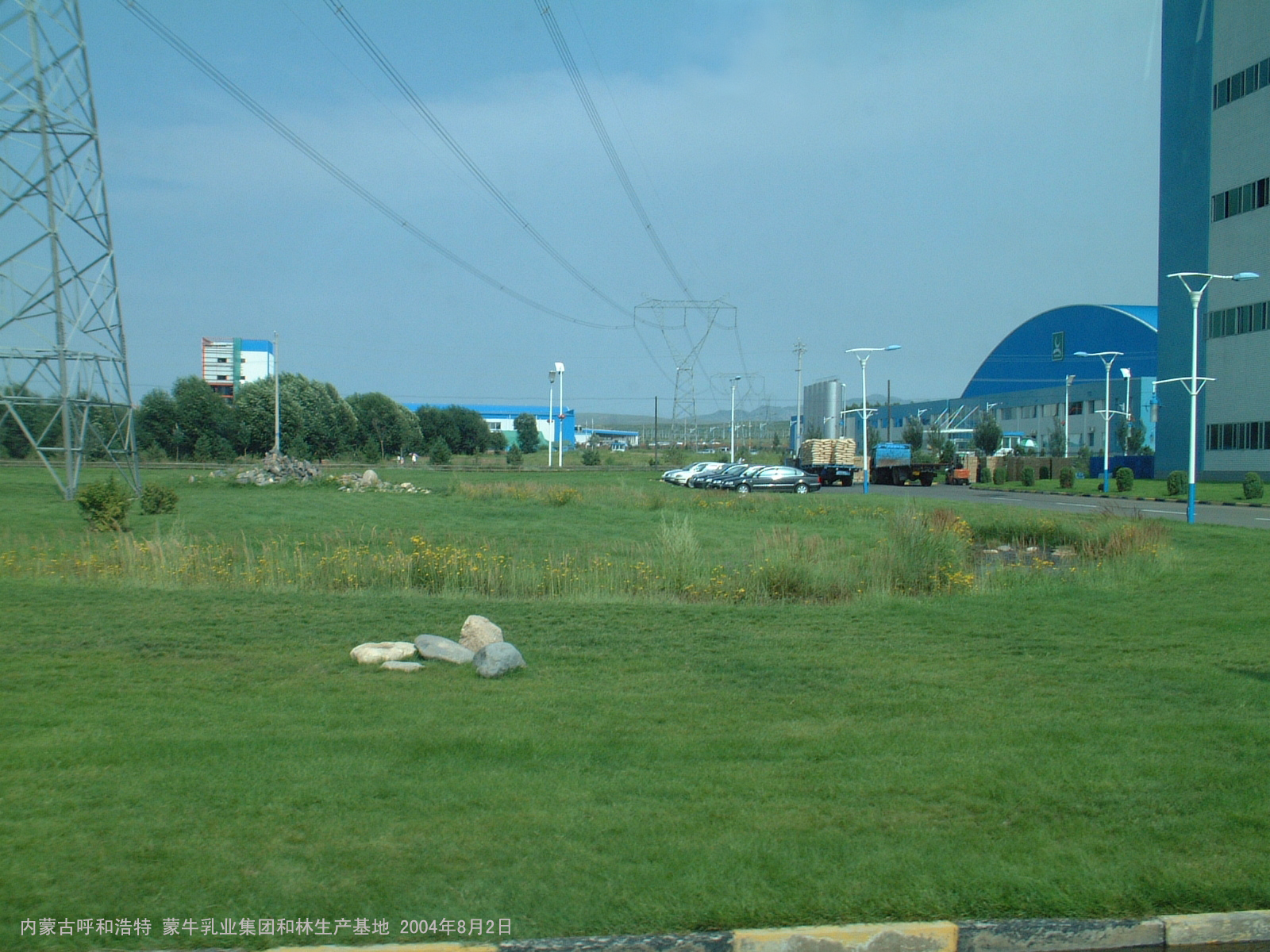 Dated 2004 exterior of a dairy production base in Horinger with buildings and vehicles