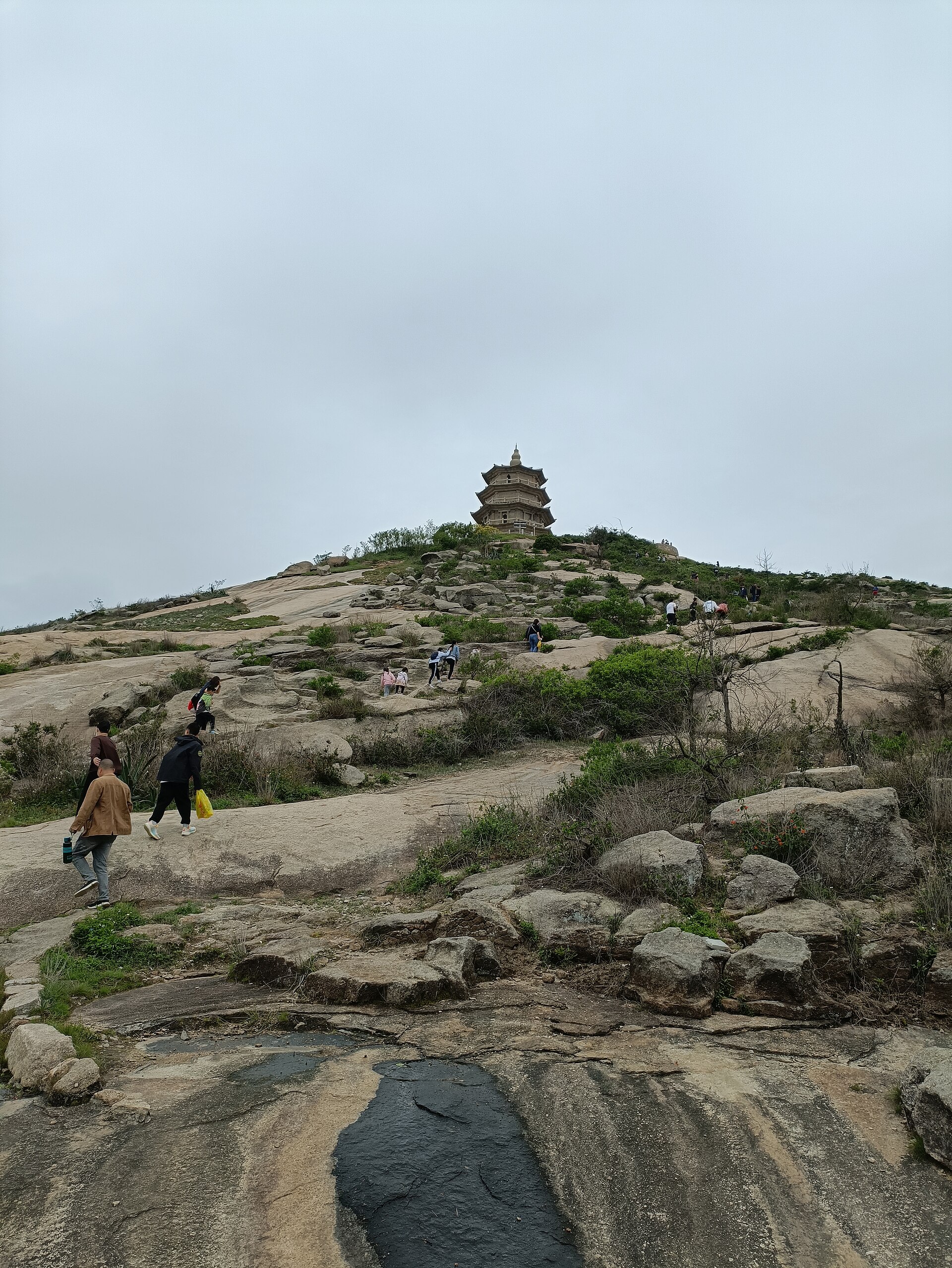 Distant Wanshou Pagoda above a rocky hill with visitors