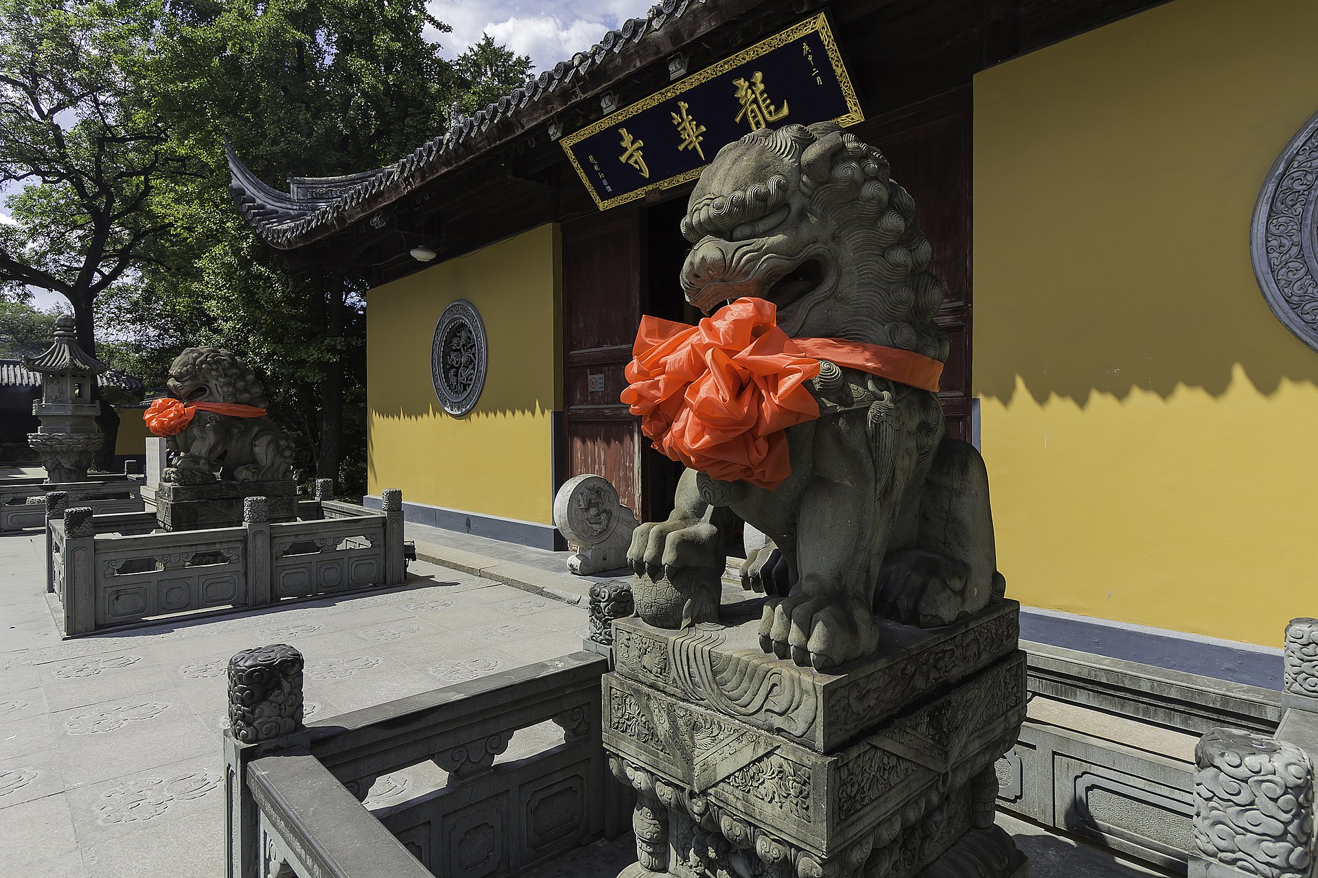 Longhua Temple entrance with yellow walls, tiled eaves and stone guardian lions