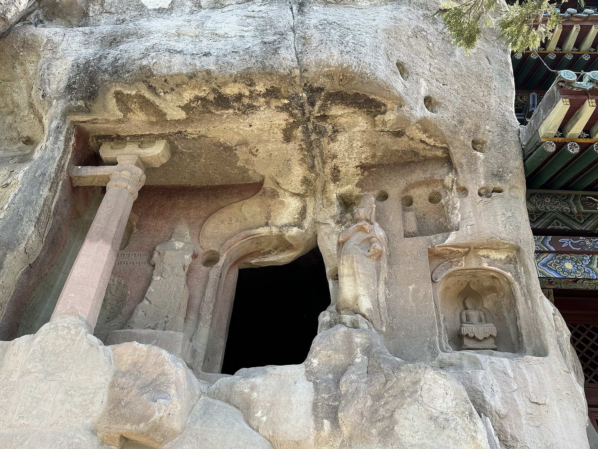 Weathered rock-cut figures, cave opening and later protective eave at Tianlongshan