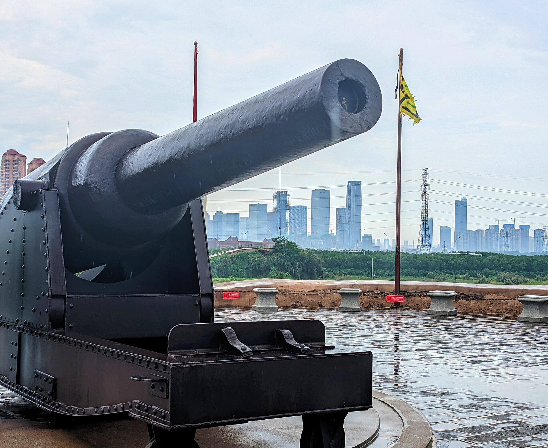 Artillery display at the Taku Fort site with modern Binhai skyline beyond