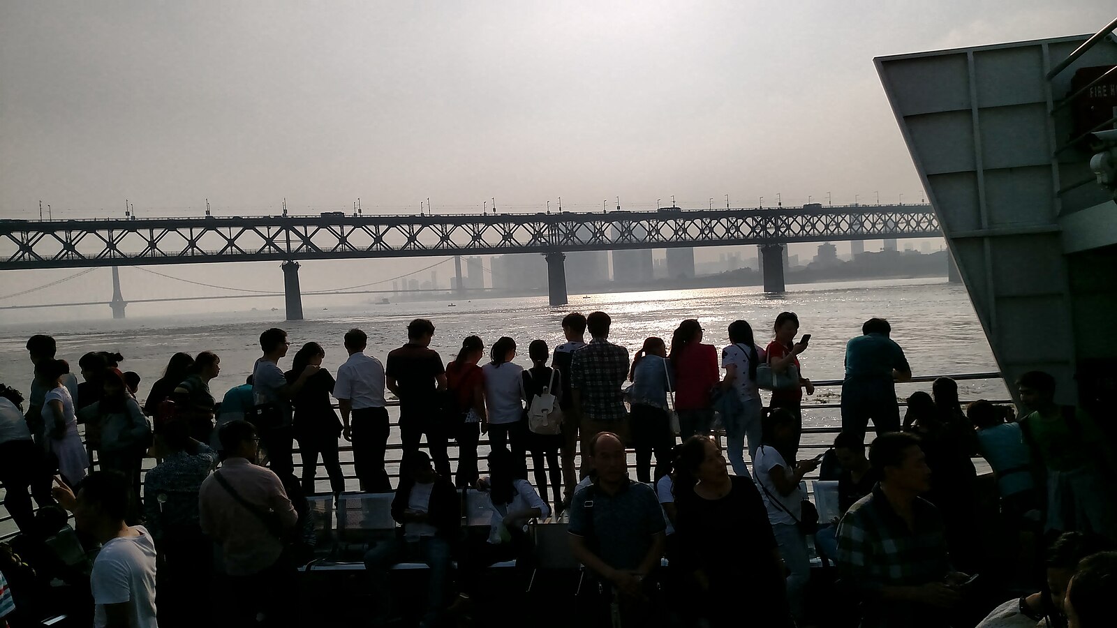 Passengers on a Wuhan ferry with the Yangtze bridge behind