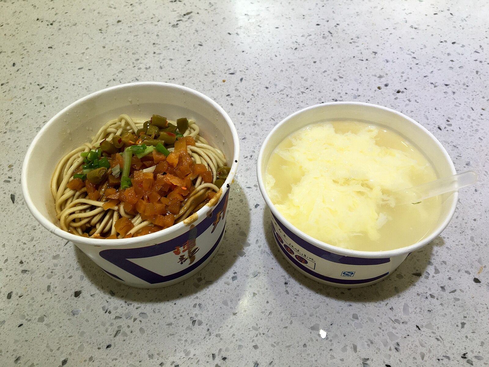 Paper bowls of hot-dry noodles and egg rice wine