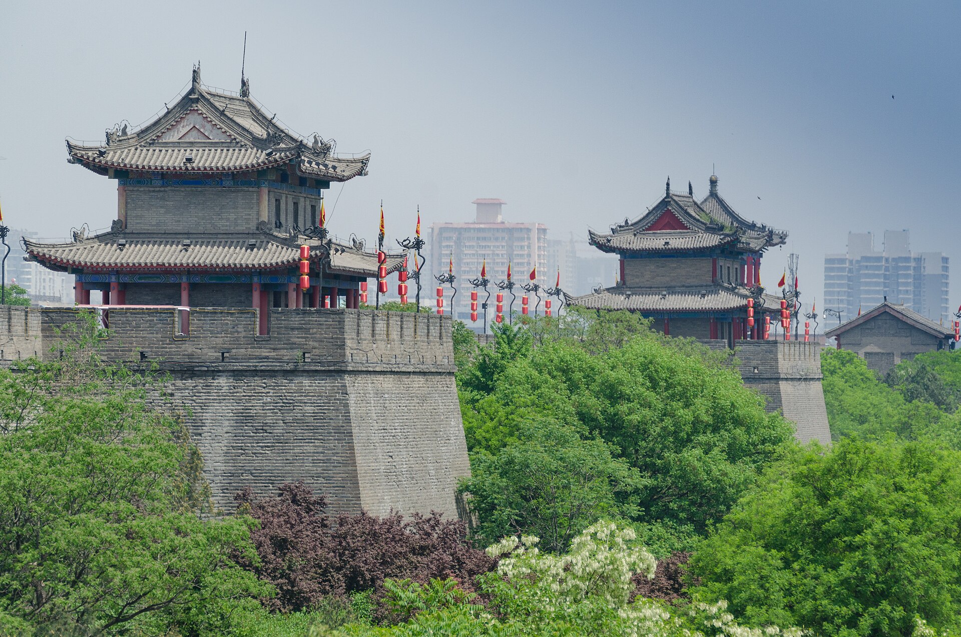 Xi'an wall ramparts and roofed towers behind a green foreground