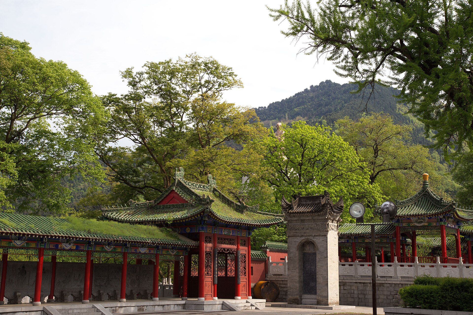 Temple roofs and trees at Louguantai beneath a wooded Qinling ridge